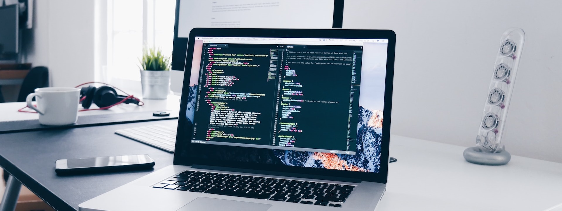 Laptop computer on a desk with programming code on the screen. Image by Christopher Gower on Unsplash